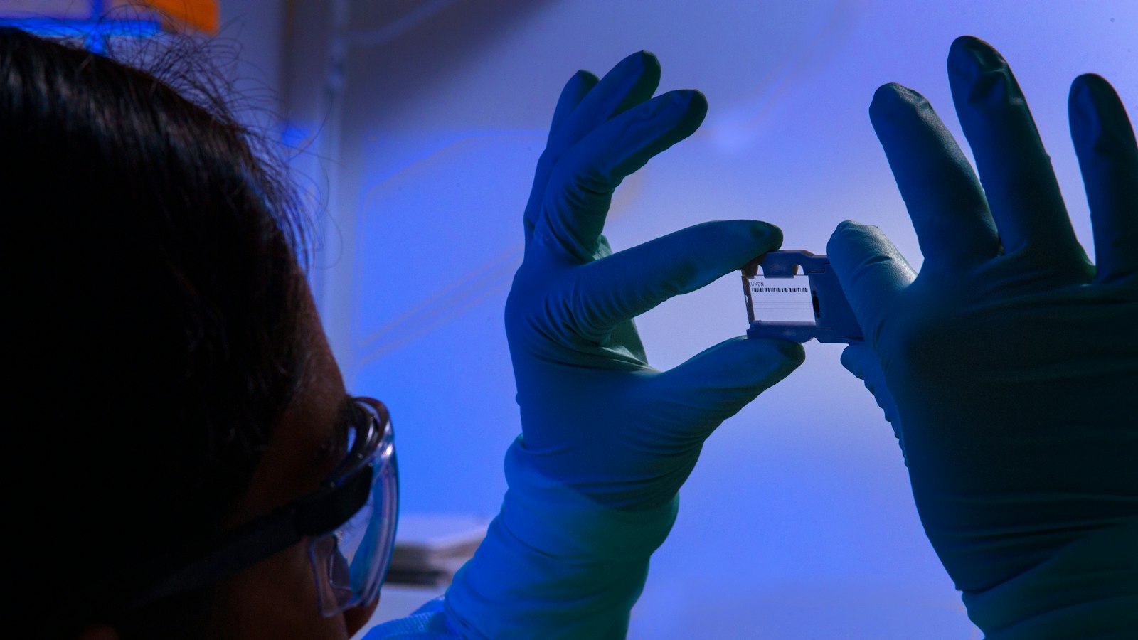 A person wearing gloves and holding up a cell phone